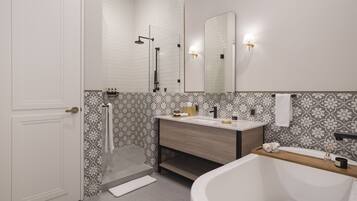 Un baño moderno con una bañera blanca, un tocador de madera, un espejo grande y cabina de ducha.