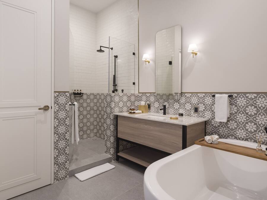 Un baño moderno con una bañera blanca, un tocador de madera, un espejo grande y cabina de ducha.