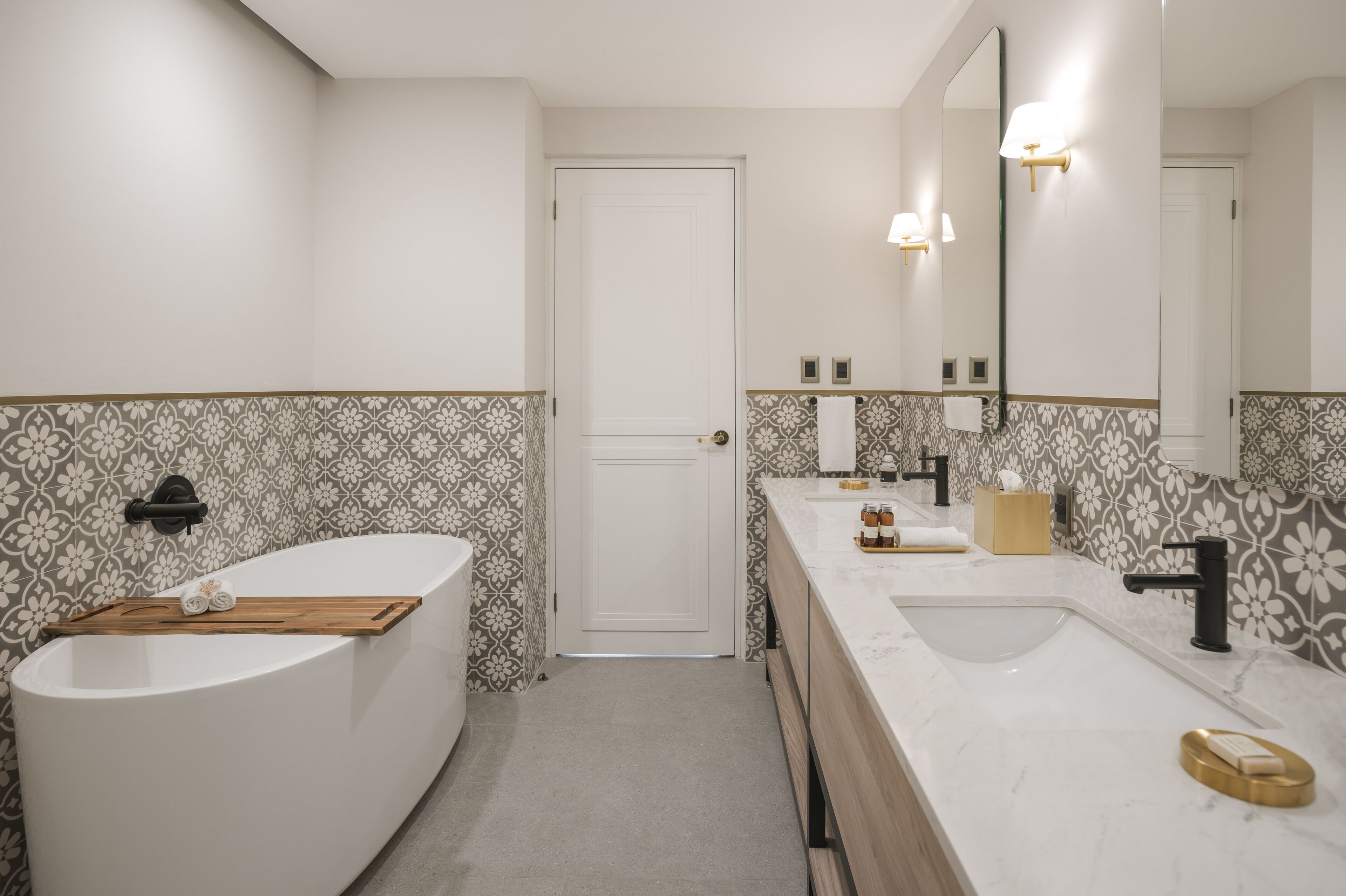 A modern bathroom with a freestanding bathtub, a vanity with a sink, and a large mirror.