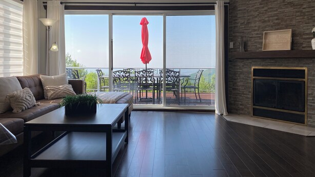 Una sala de estar moderna con un sofá, una mesa de centro y un comedor con sillas y un paraguas rojo.