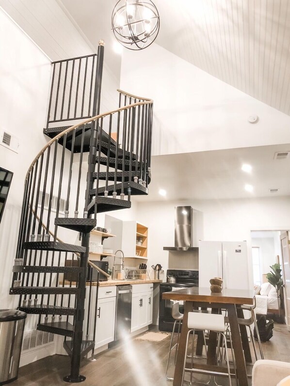 A modern kitchen with a central island, a built-in oven, and a stainless steel range hood.