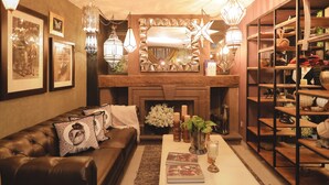 Un salon chaleureux avec une cheminée, un canapé en cuir et un éclairage décoratif.
