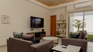 Ein modernes Wohnzimmer mit zwei Sofas, einem Couchtisch, einem Fernseher und einem Bücherregal.