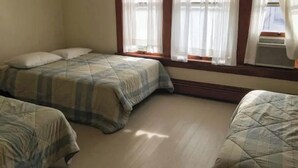 Camera da letto con due letti, una finestra con tende e un termosifone.
