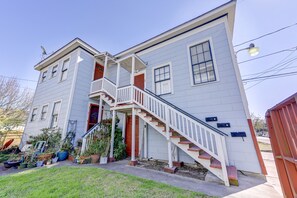 Ein zweistöckiges Haus mit Veranda, Treppe und Garage.