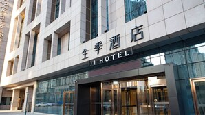 A hotel entrance with a modern facade, large glass doors, and a sign indicating it's a hotel. - Ji Hotel (Shijiazhuang)