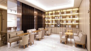 A modern hotel lobby with a central seating area, a bar, and a large bookshelf. - Ji Hotel (Shijiazhuang)