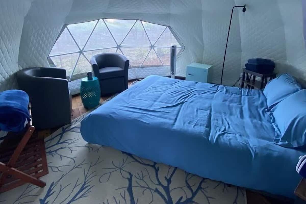 Une pièce de style igloo comprenant un lit, une chaise et une petite table.