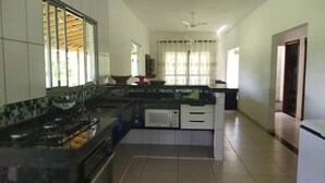 Una cocina con estufa a gas, microondas y lavaplatos.