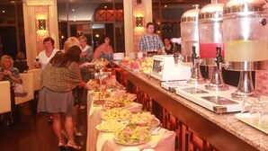 Ein reichhaltiges Buffet mit verschiedenen Speisen und einer Kaffeestation.