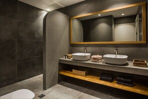 Ein modernes Badezimmer mit zwei Waschbecken, einem großen Spiegel und einer Duschkabine.