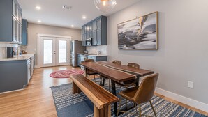Una cocina moderna con armarios grises, una mesa de comedor de madera y un banco.