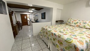 A bedroom with a bed, a desk, and a chair. - In the heart of West End, Roatan - Mariposa Lodge - Unit 2 (West End)
