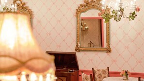 Een kamer met een kroonluchter, een spiegel en bloemdecoraties.
