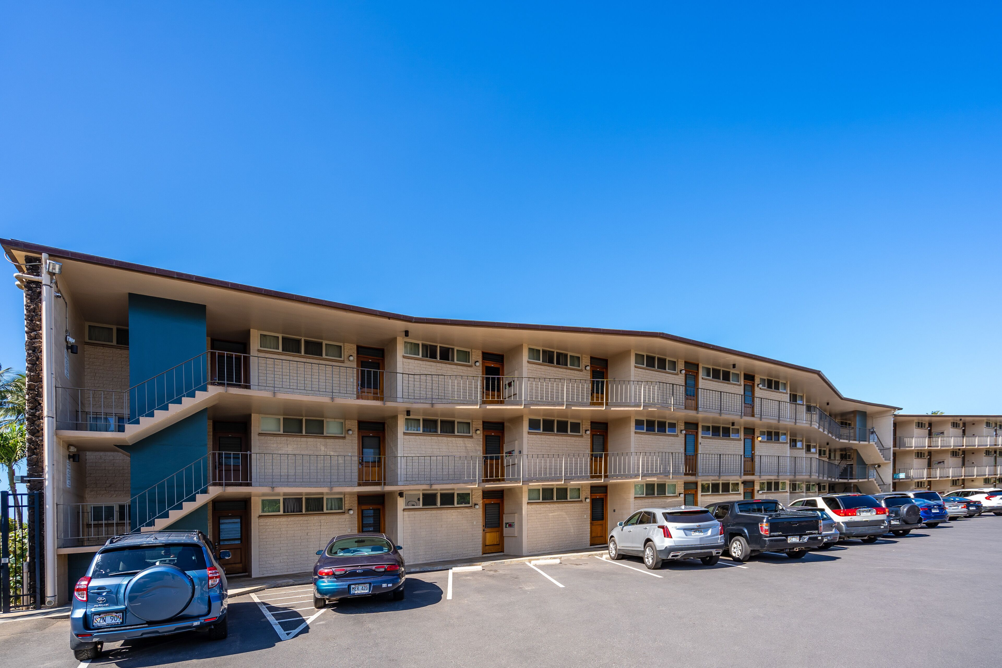 A multi-story motel with a parking lot.