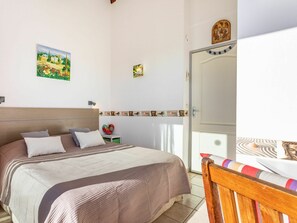 Un dormitorio con cama, mesita de noche, espejo y puerta.