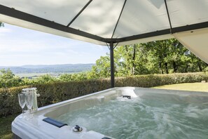 Ein Whirlpool mit Blick auf die Landschaft, umgeben von viel Grün.