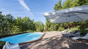 En pool med solstolar och ett överbyggt område.