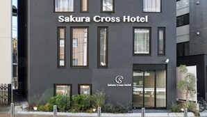 Exterior del Hotel Sakura Cross con un diseño moderno, destacando amplias ventanas y una fachada minimalista.