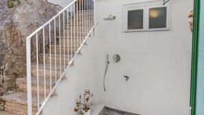 Una escalera que conduce a una habitación con ducha y ventana.