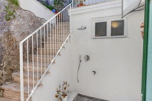 Una escalera que conduce a una habitación con ducha y ventana.