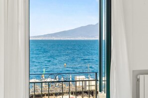 Ein Balkon mit Blick auf das Meer und ein ferner Berg.