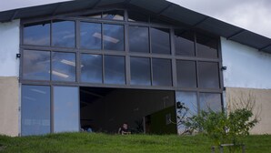Ein großes Industriegebäude mit geöffneter Garagentür, dahinter ist eine Person sichtbar.