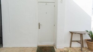 A white door with a handle and a small mat in front.