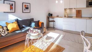 Una sala de estar moderna con un sofá, una mesa de centro y una obra de arte en la pared.