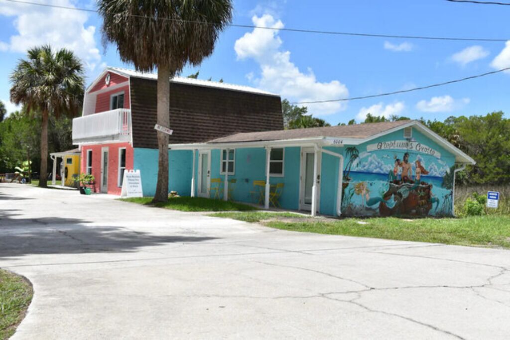A two-story building with a mural on the side, a porch, and a sign indicating 'Apt. 404'.