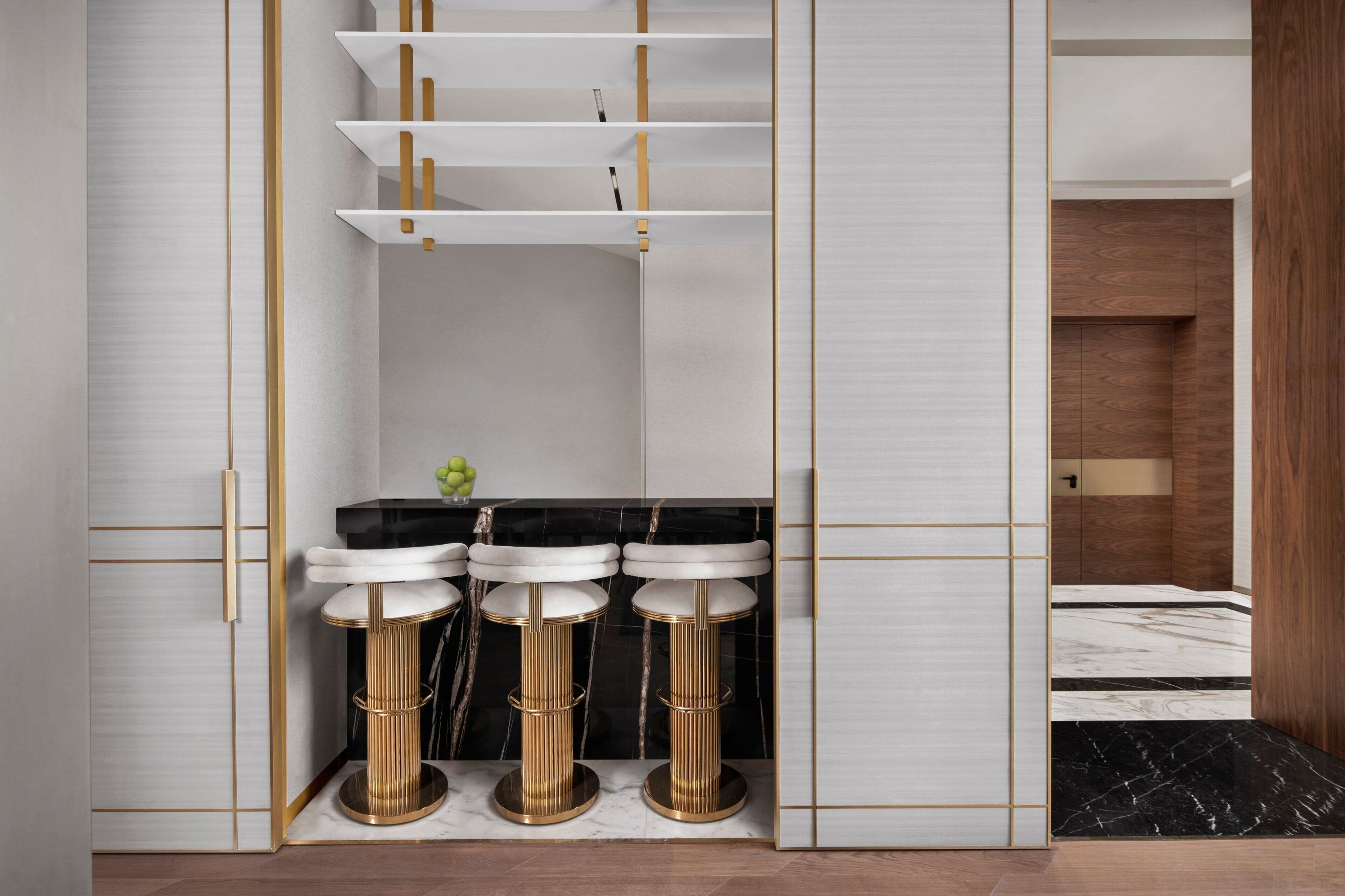 Een moderne badkamer met drie wasbakken op voetstuk, een zwart marmeren aanrechtblad en een houten badmeubel.
