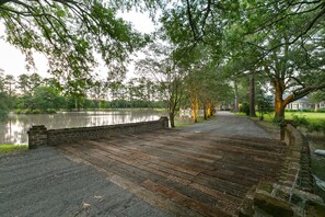 Eine Holzbrücke führt zu einem Haus am See.