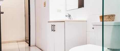 Un baño moderno con inodoro, lavabo y armario.