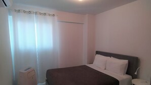 Ein Schlafzimmer mit Bett, Nachttisch und einem kleinen Heizgerät.