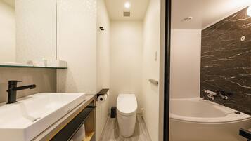 A modern bathroom with a white sink, toilet, and bathtub.