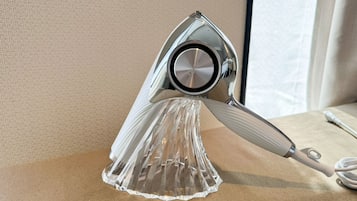 A metallic, reflective object with a circular center, possibly a decorative item, placed on a textured surface.