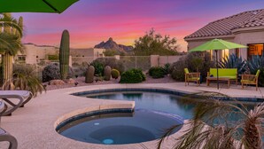 A swimming pool with a desert landscape in the background, surrounded by cacti and shrubs. - ★ Jump in! ★ Luxurious spread in the desert & no annoying neighbors! Comfy beds! (Fountain Hills)
