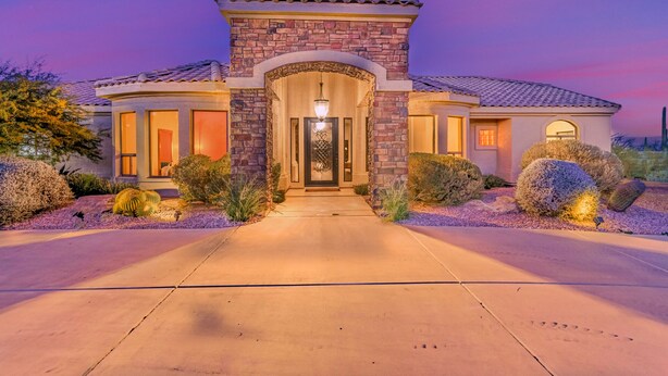A two-story house with a stone entrance, large windows, and a well-lit driveway. - ★ Jump in! ★ Luxurious spread in the desert & no annoying neighbors! Comfy beds! (Fountain Hills)
