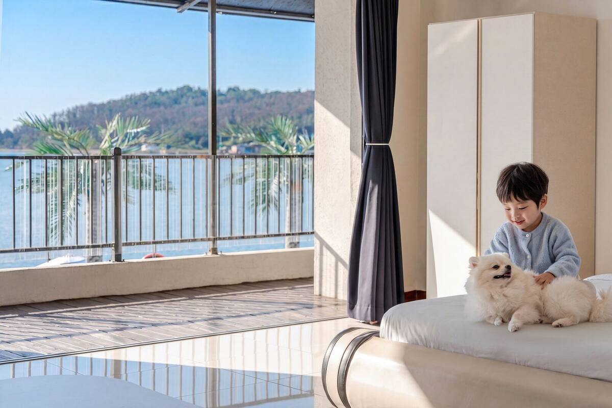 A bedroom with a large bed, a balcony with a view of the water, and a child with a dog.