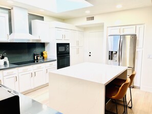 Enjoy cooking in this kitchen with a central island, oven, and stainless steel refrigerator.