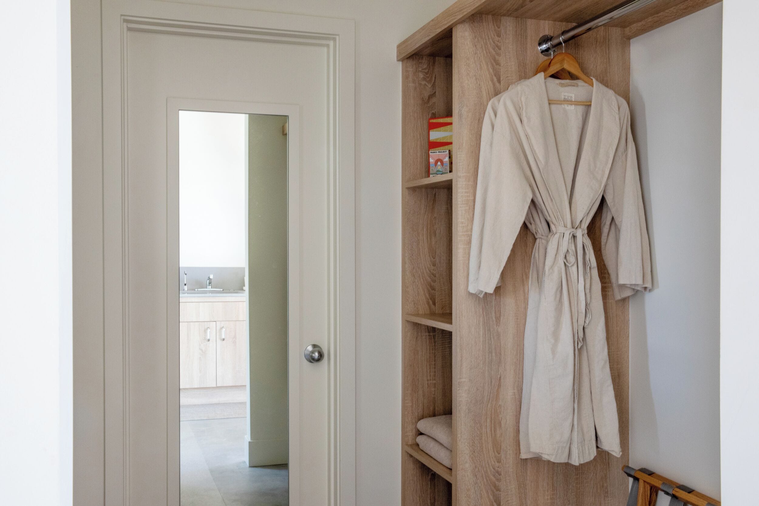 Une armoire en bois avec un manteau suspendu à un cintre.