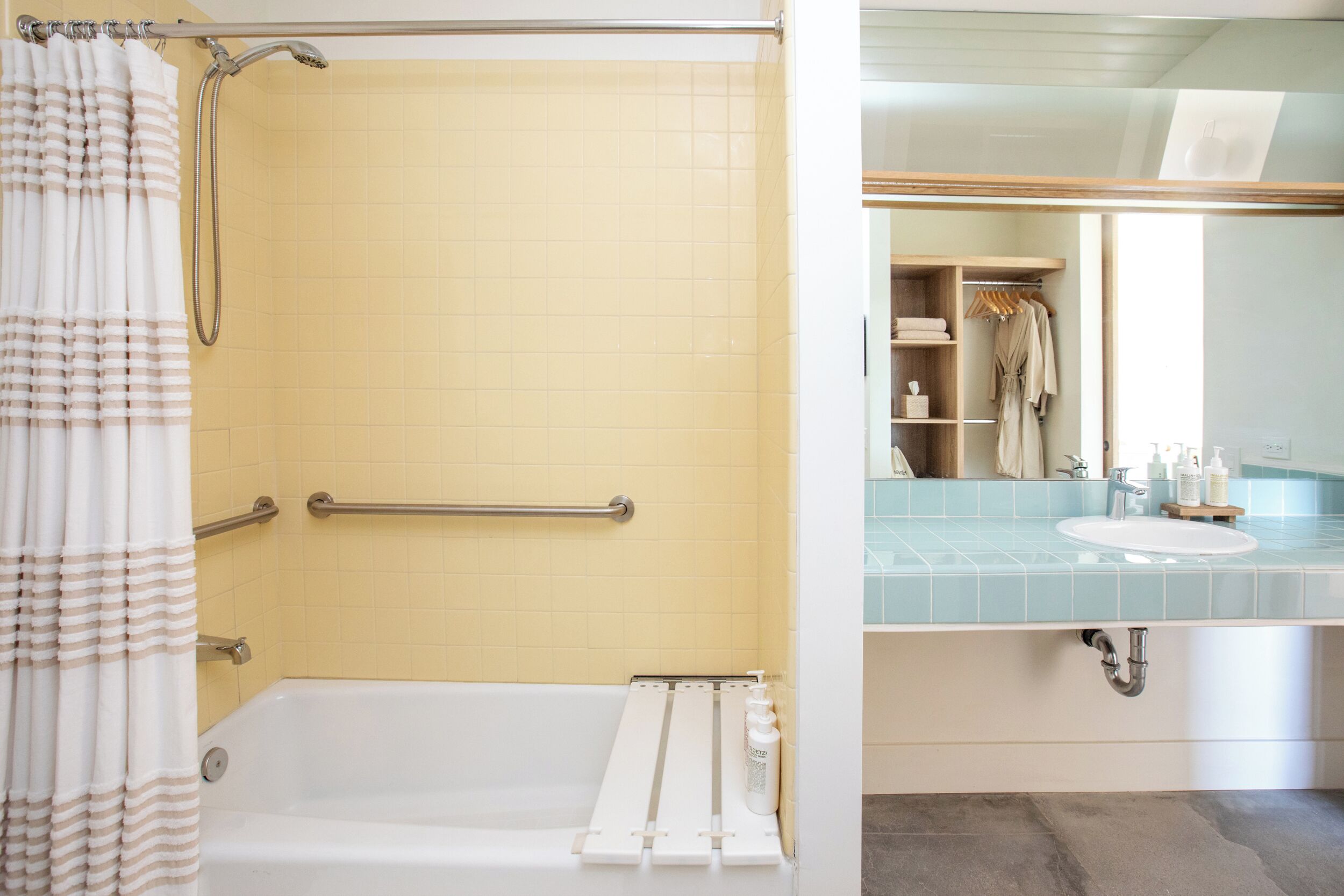 A bathroom with a bathtub, a shower, a towel rack, and a sink with toiletries.
