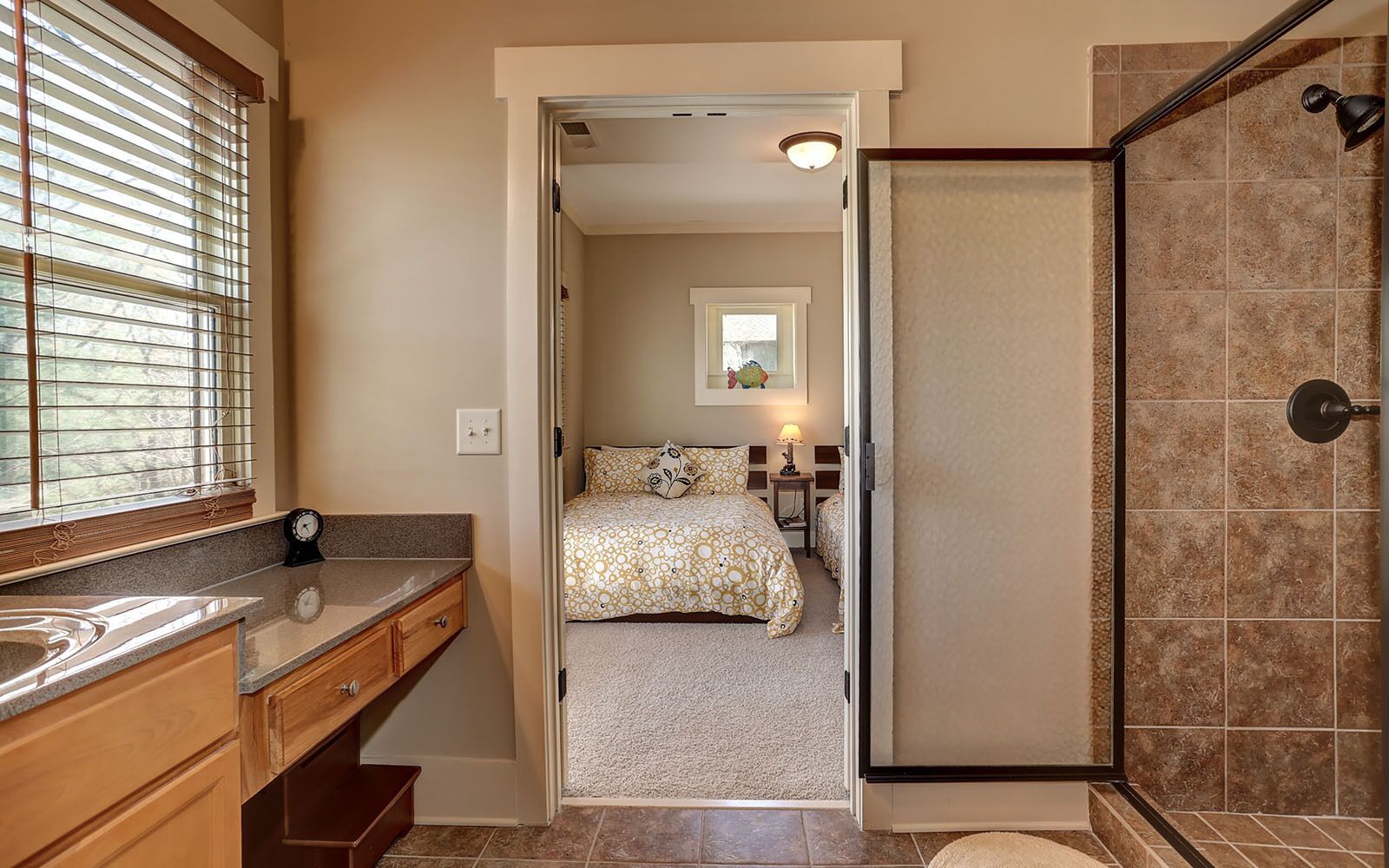 A bathroom with a shower, toilet, sink, and a mirror.