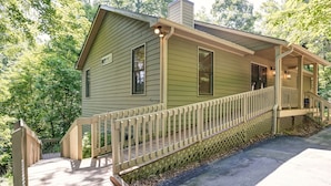 A green house with a wooden deck and a porch. - Cozy Retreat with Fireplace, Netflix & Easy Ramp Access - Deer View Retreat (Jasper)