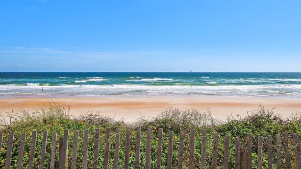 A beach with waves, a wooden fence, and a clear sky. - BIG Backyard w/Terrace|Dining|Games | 6min2Beach (St. Augustine)