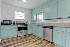Enjoy cooking in this well-lit kitchen with a microwave, oven, and dishwasher.