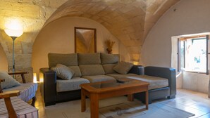 Una sala de estar acogedora con un sofá, una mesa de centro y una lámpara.