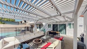 Un espace extérieur abrité comprenant une piscine, des sièges et un escalier menant à un niveau supérieur.