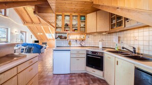 Eine Küche mit Holzausstattung, einem eingebauten Backofen und einem Geschirrspüler.