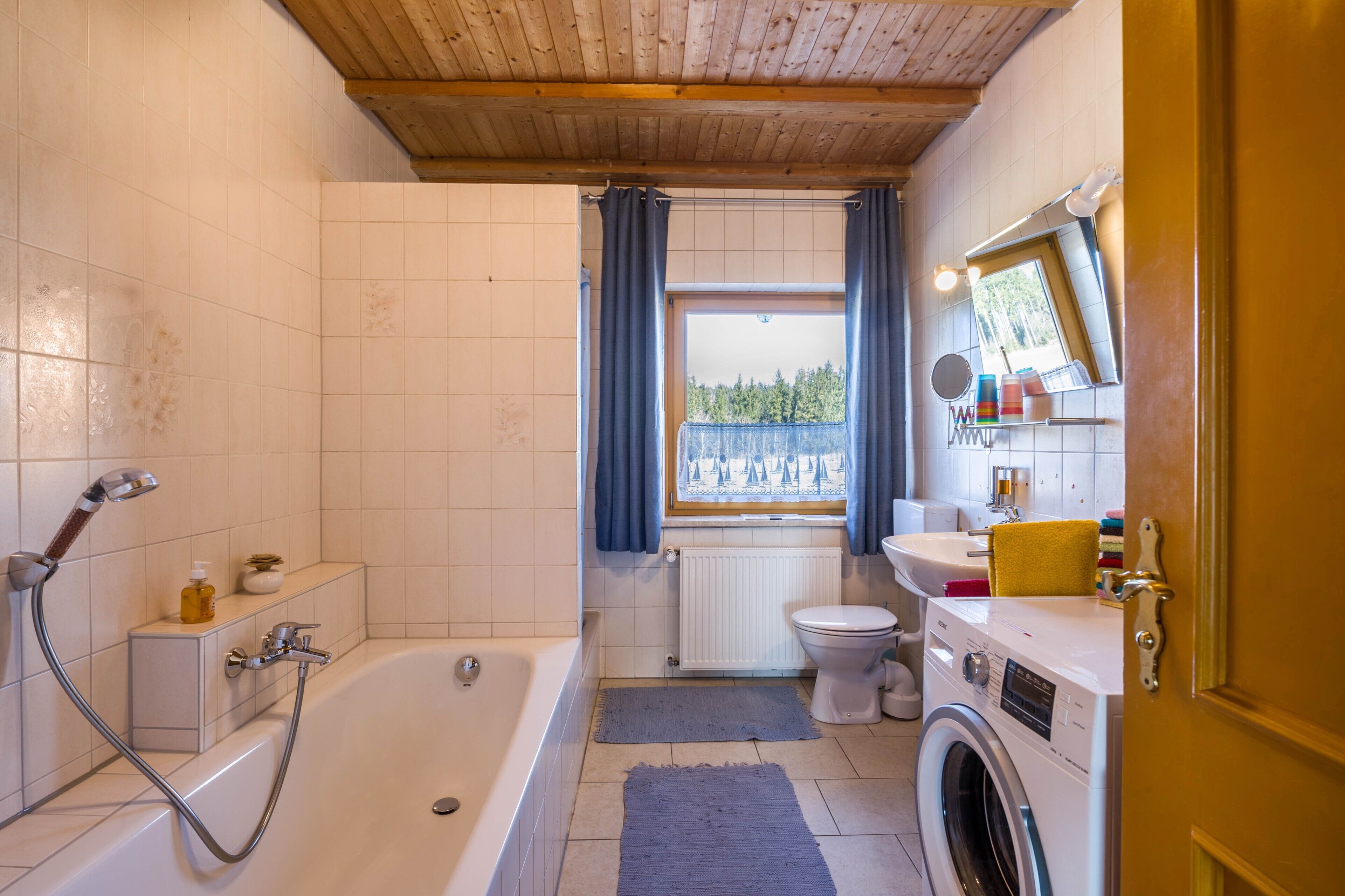 Ein Badezimmer mit Badewanne, Toilette und Waschmaschine.